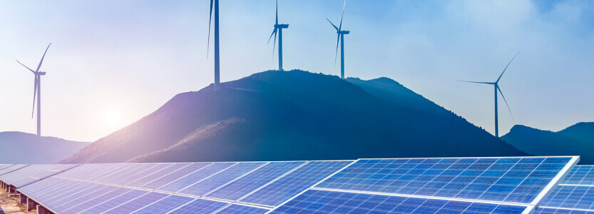 photo of renewable energy production site (wind turbines and solar panels)